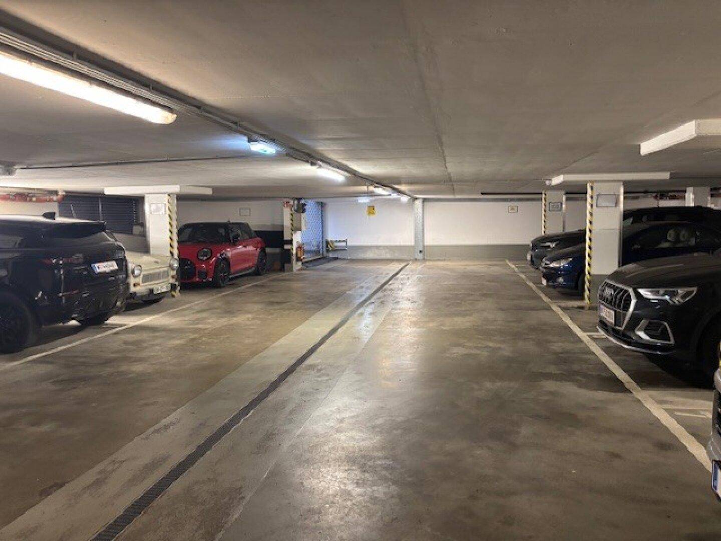 Geräumige Tiefgarage mit mehreren Stellplätzen und Betonboden.