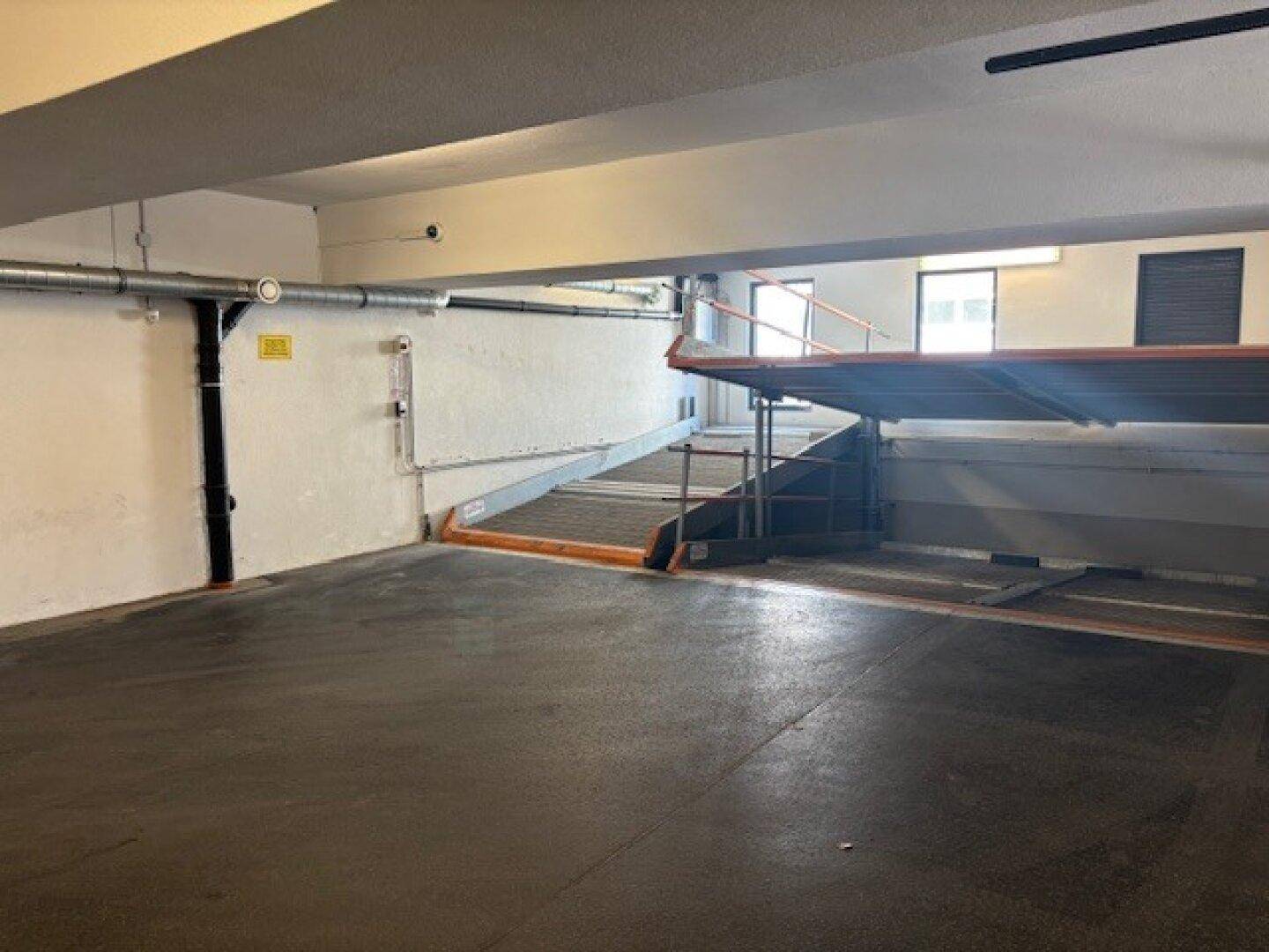 Tiefgarage mit Zufahrtsrampe und ausreichend Platz für Fahrzeuge.