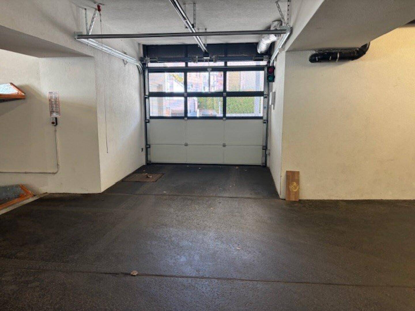 Einzelner Garagenstellplatz mit Rolltor in einer Tiefgarage.