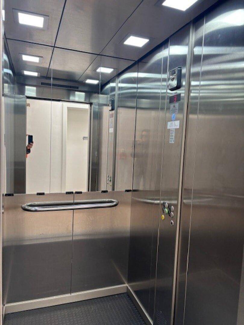 Moderner Aufzug mit Edelstahloberflächen und Spiegeln, bietet Zugang zu allen Etagen.