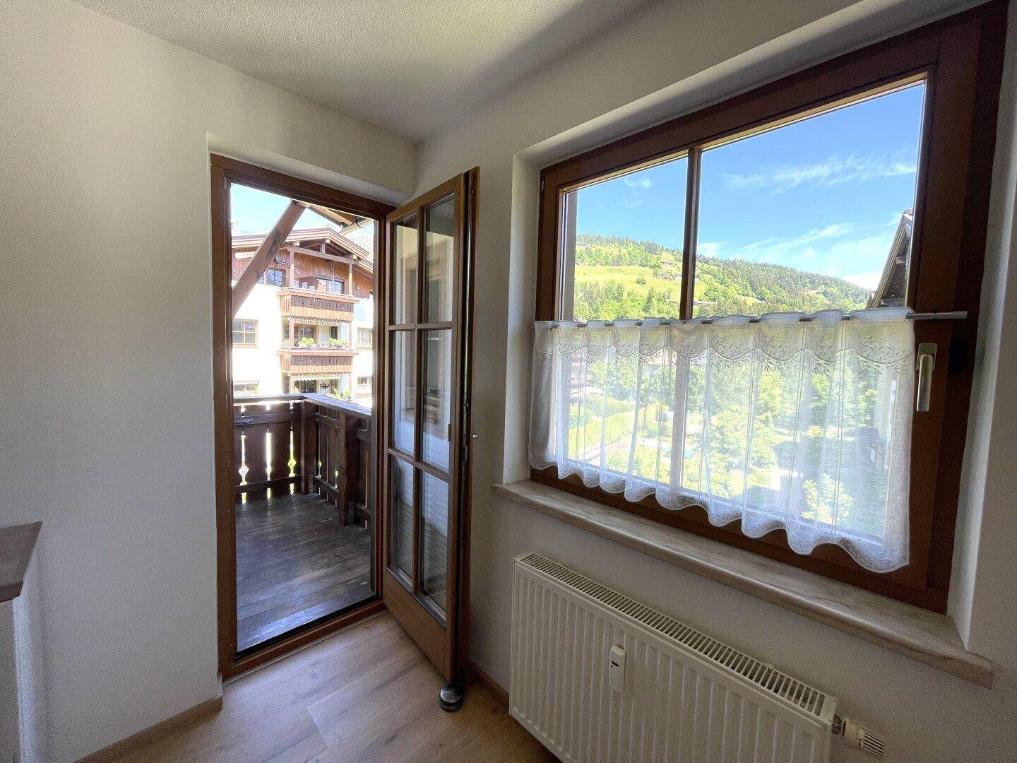 Kleiner Bereich mit Fenster und Balkonzugang, bietet einen Blick ins Grüne.