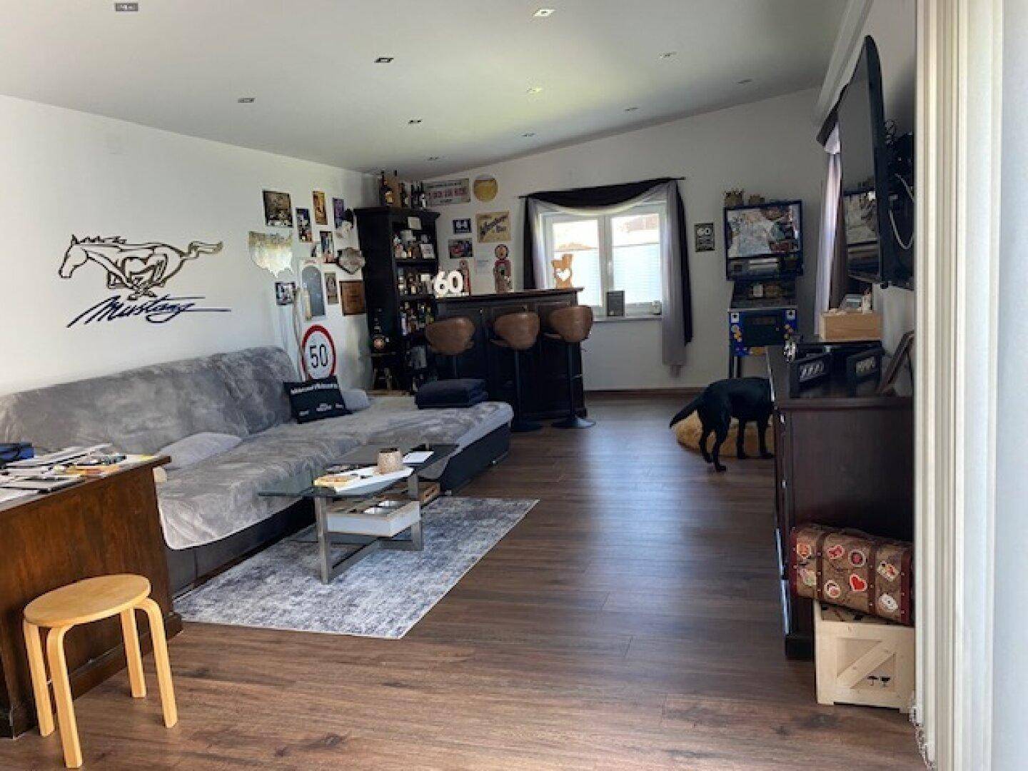 Geräumiges Wohnzimmer mit großem Sofa, Bar und Unterhaltungsecke.