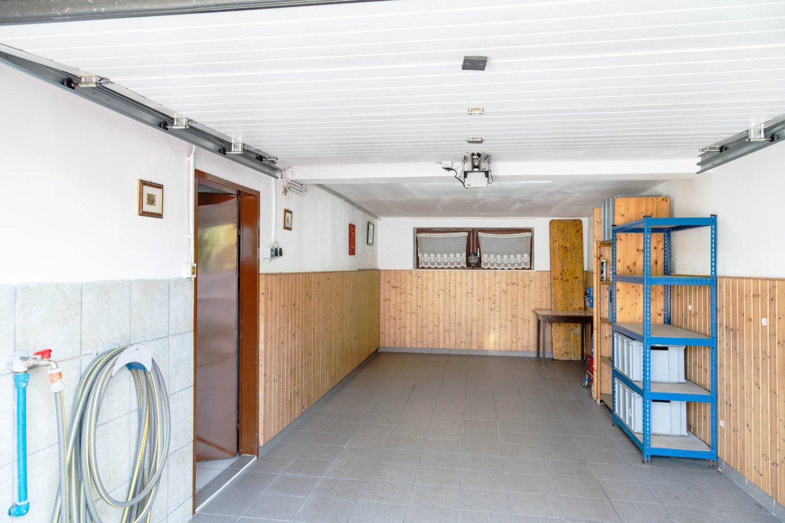 Geräumige Garage mit Stauraum, Holzvertäfelung und Zugang zur Straße.