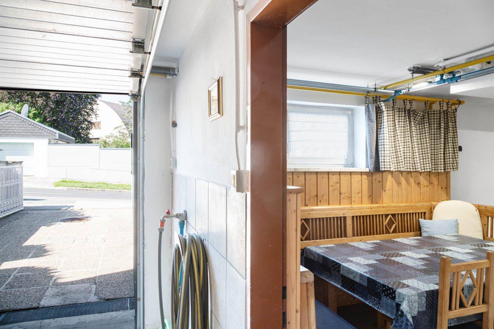 Teil der Garage mit Sitzgelegenheit und Blick auf die Einfahrt.