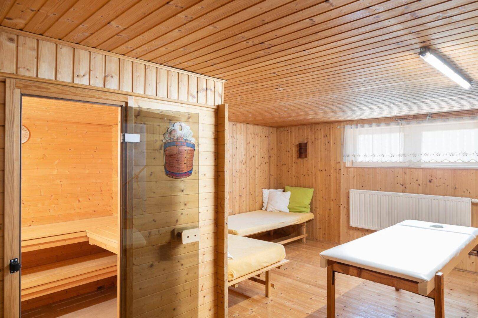 Entspannender Wellnessbereich mit Sauna, Holzvertäfelung und Liegemöglichkeiten.