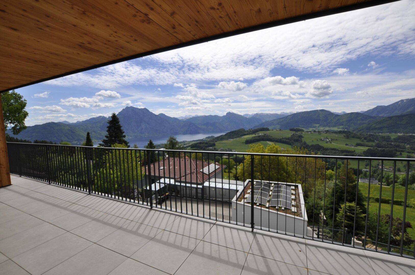 Geräumiger Balkon mit Fliesenboden und atemberaubendem Blick auf Berge und See.