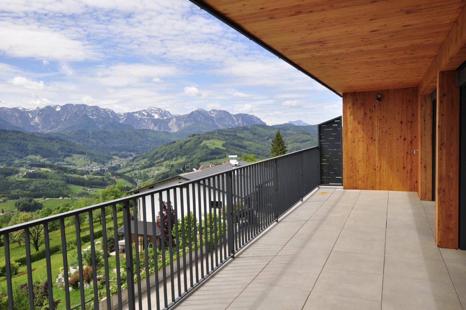 Langer Balkon mit Holzverkleidung und beeindruckendem Blick auf die umliegende Berglandschaft.
