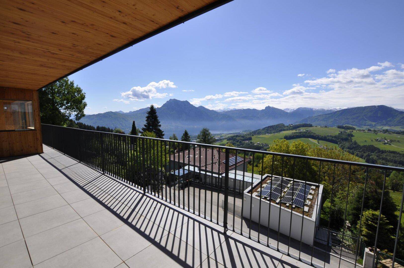 Geräumiger Balkon mit Fliesenboden und atemberaubendem Blick auf Berge und See.
