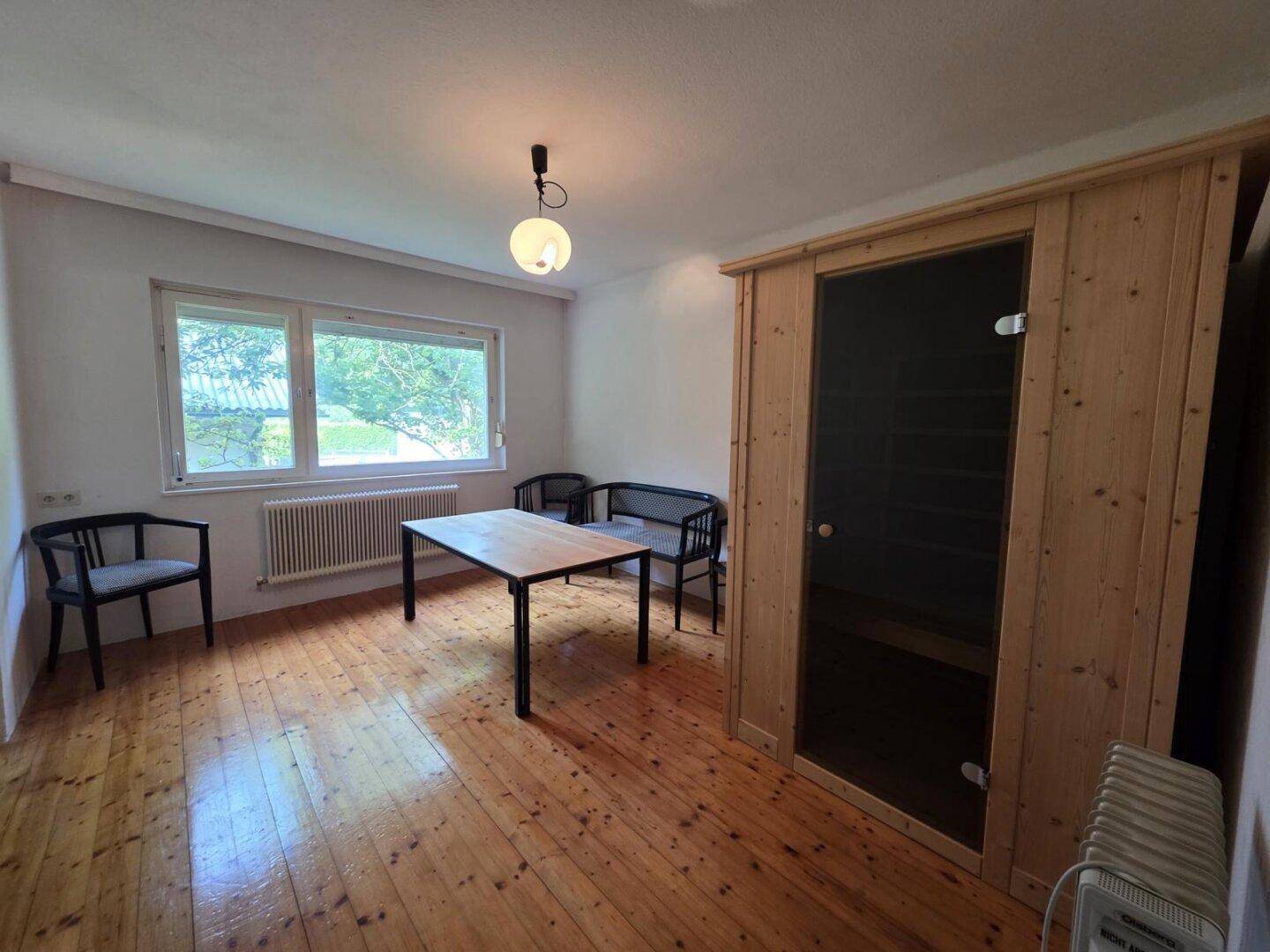 Raum mit Holzboden und einer eingebauten Sauna, ideal für Entspannung und Wellness.