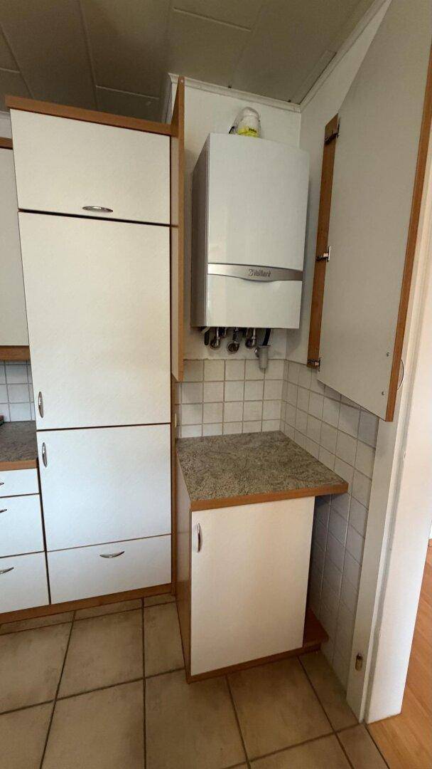 Hauswirtschaftsraum mit Warmwasserbereiter und zusätzlichen Stauschränken.