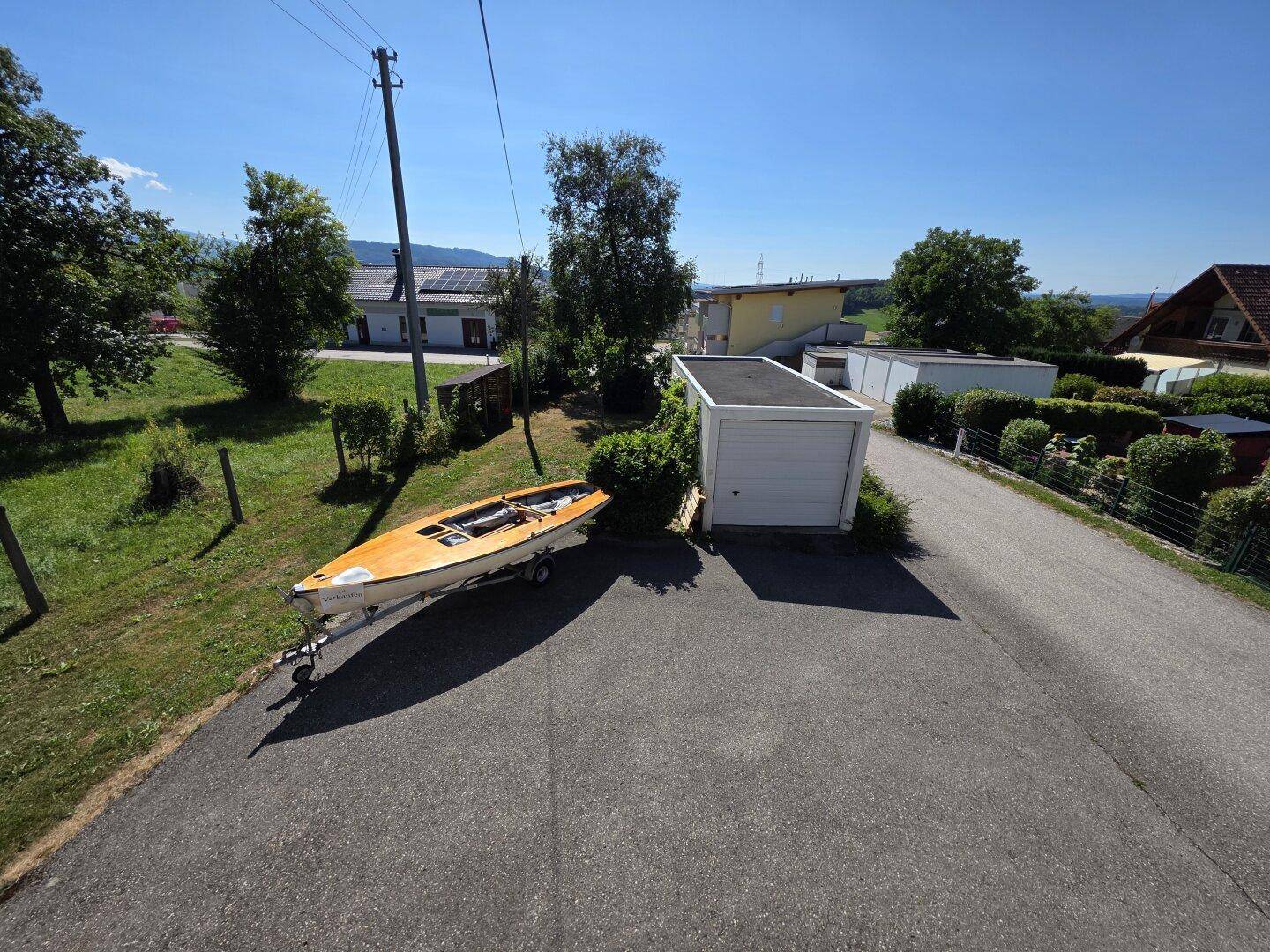 Außenbereich mit Garage, Stellplatz und Blick auf die Umgebung.