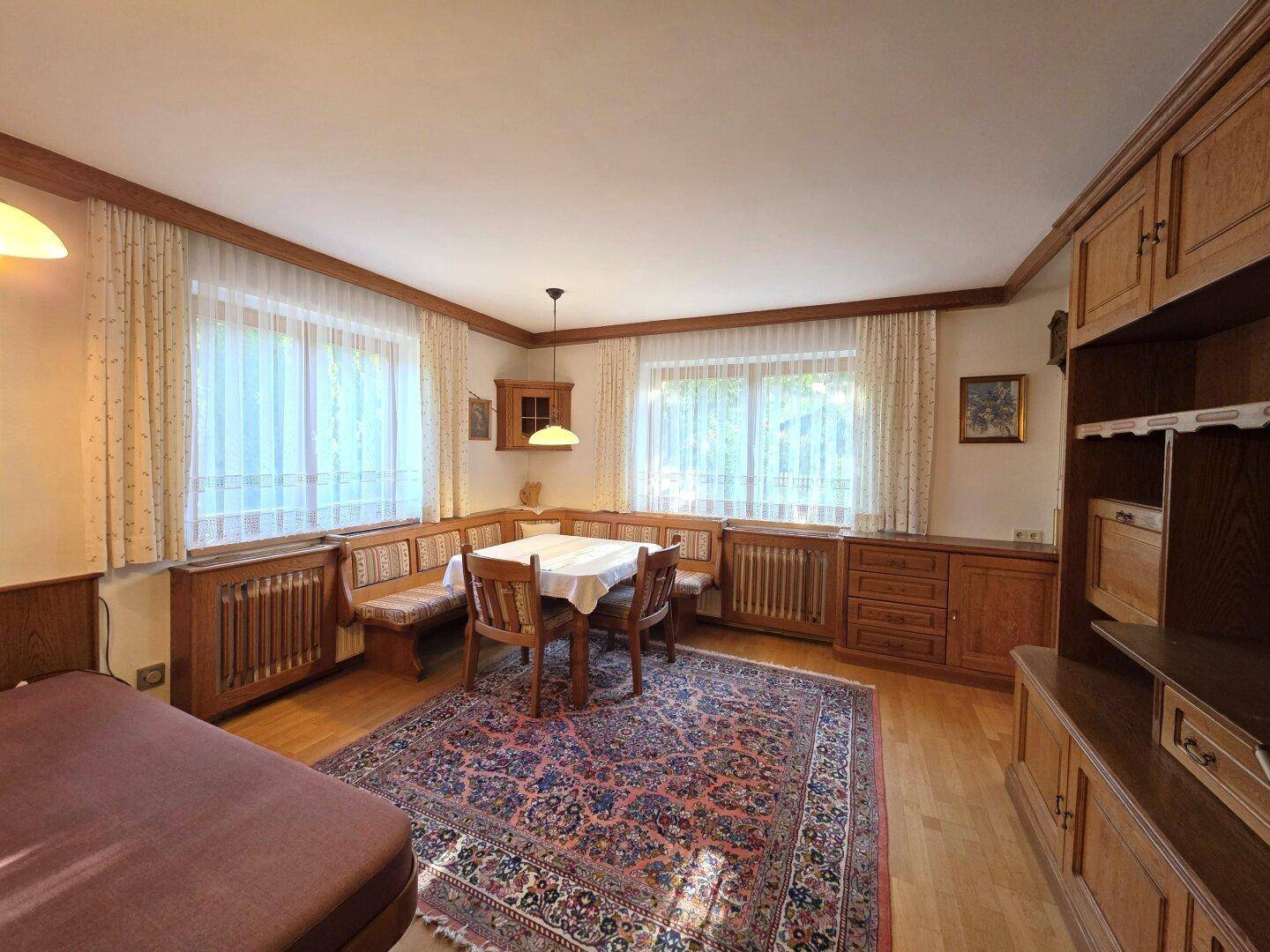 Gemütliches Wohnzimmer im Landhausstil mit Holzboden und traditionellen Möbeln.