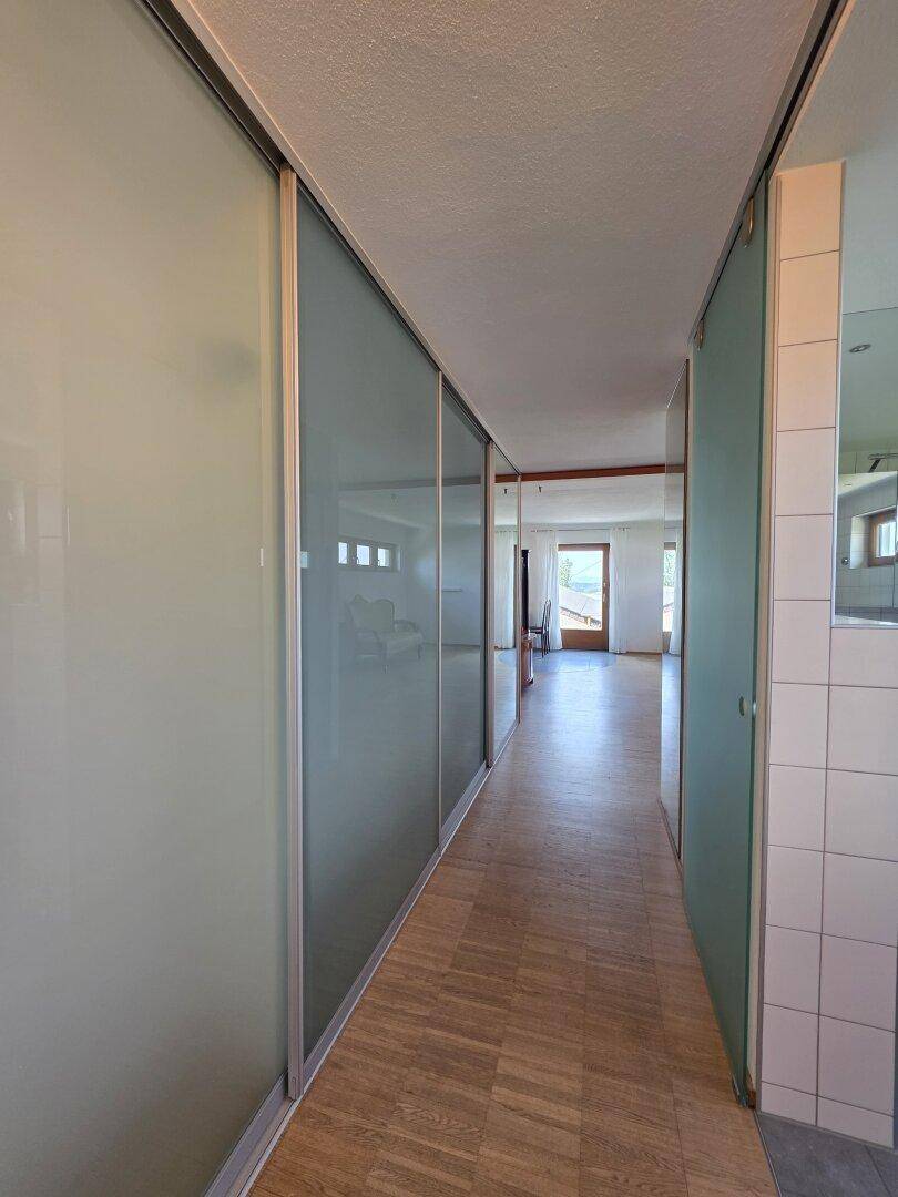 Heller Flur mit Holzparkett und modernen Schiebetüren aus Milchglas.