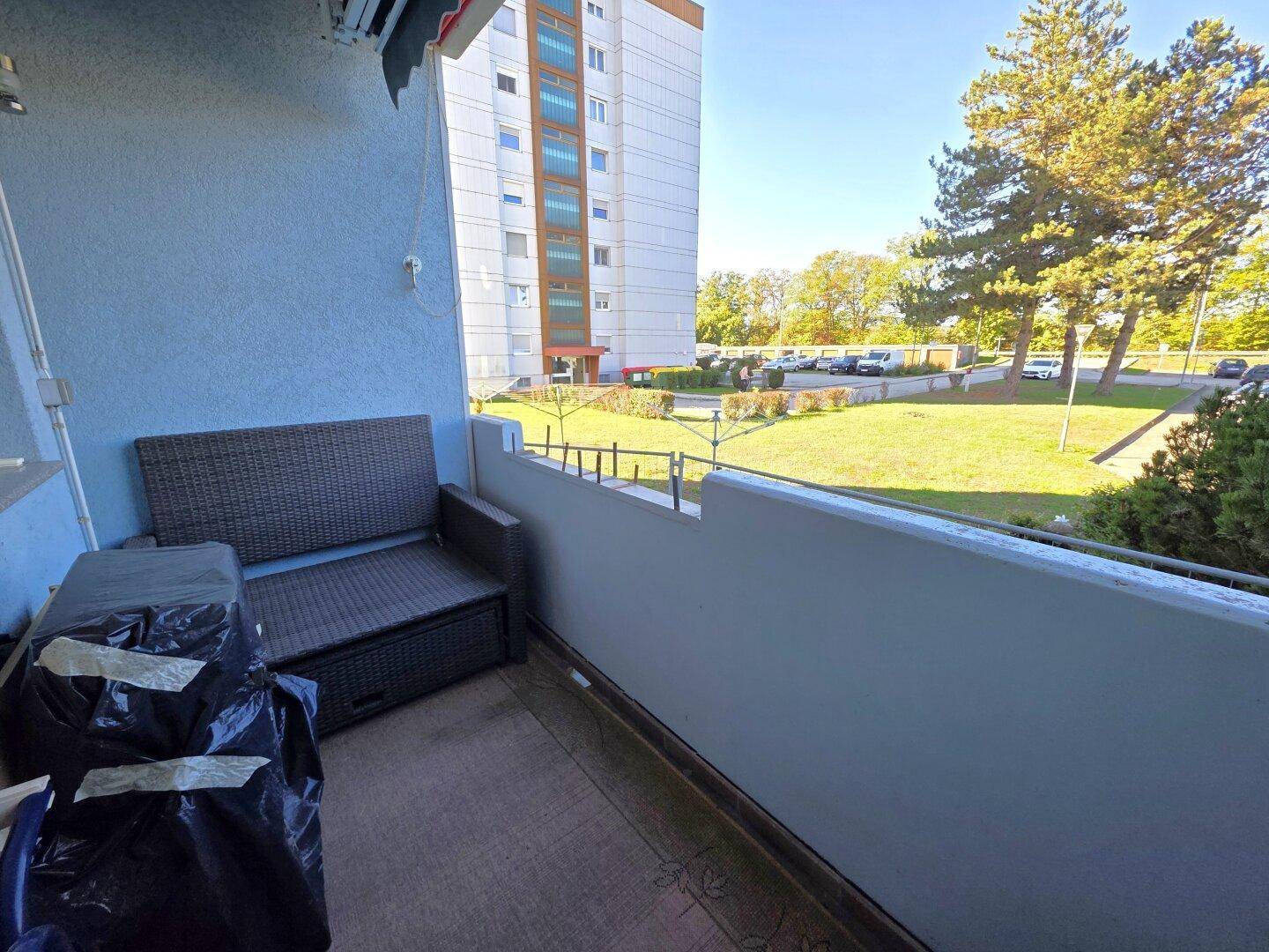 Sonniger Balkon mit Sitzgelegenheiten und Blick auf die Umgebung, ideal zum Entspannen im Freien.
