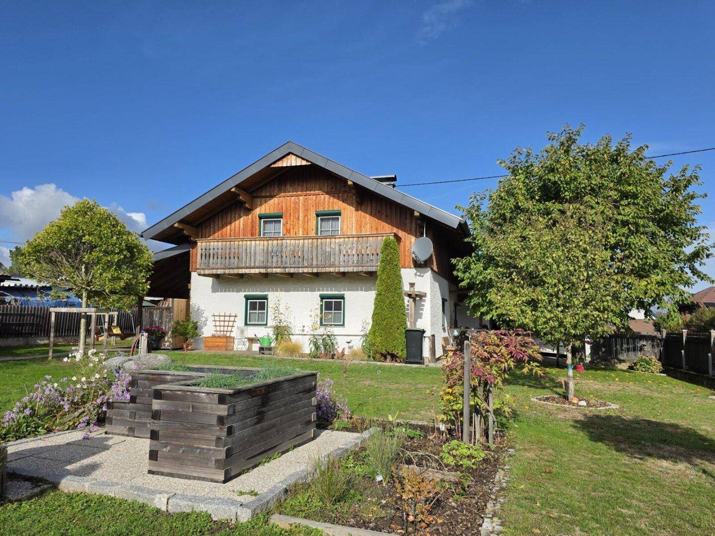 Charmantes Haus mit Holzfassade und einem liebevoll angelegten Gartenbereich mit Hochbeet.