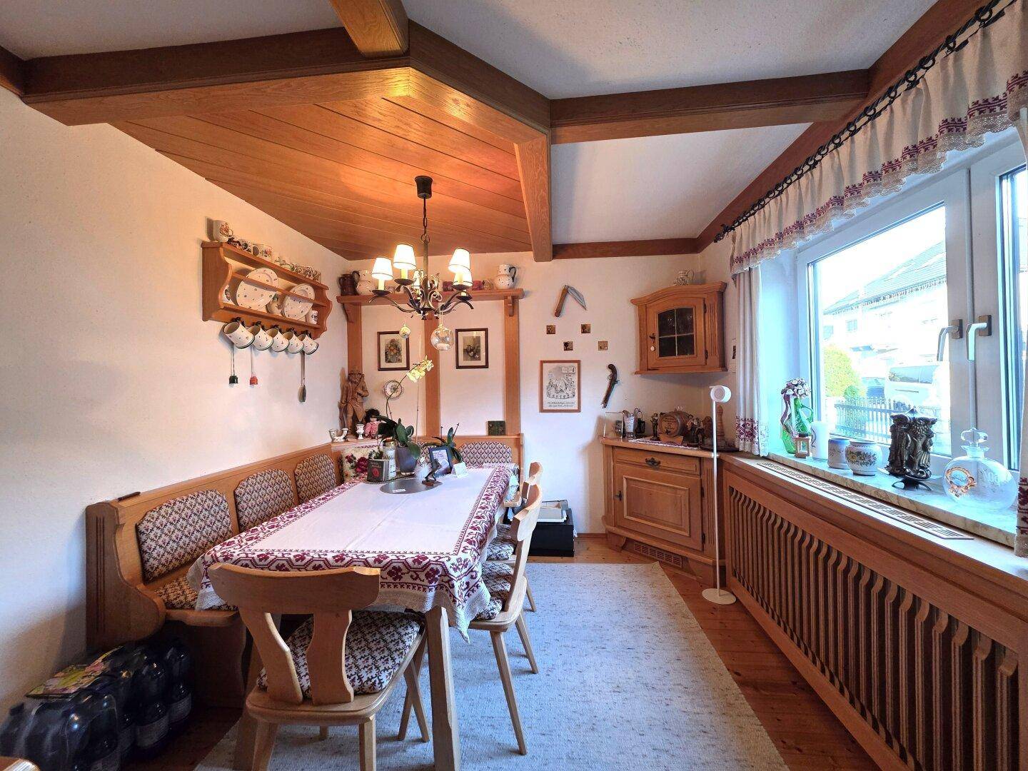 Rustikaler Essbereich mit Holzbalkendecke, Eckbank und traditionellen Holzmöbeln.