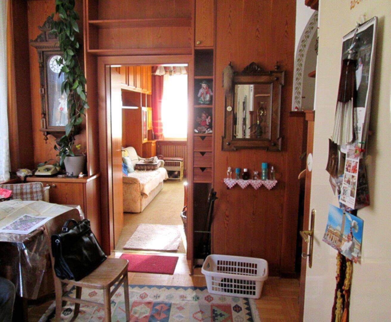 Flur mit Holzvertäfelung, einem Teppich und Blick in einen angrenzenden Wohnbereich.