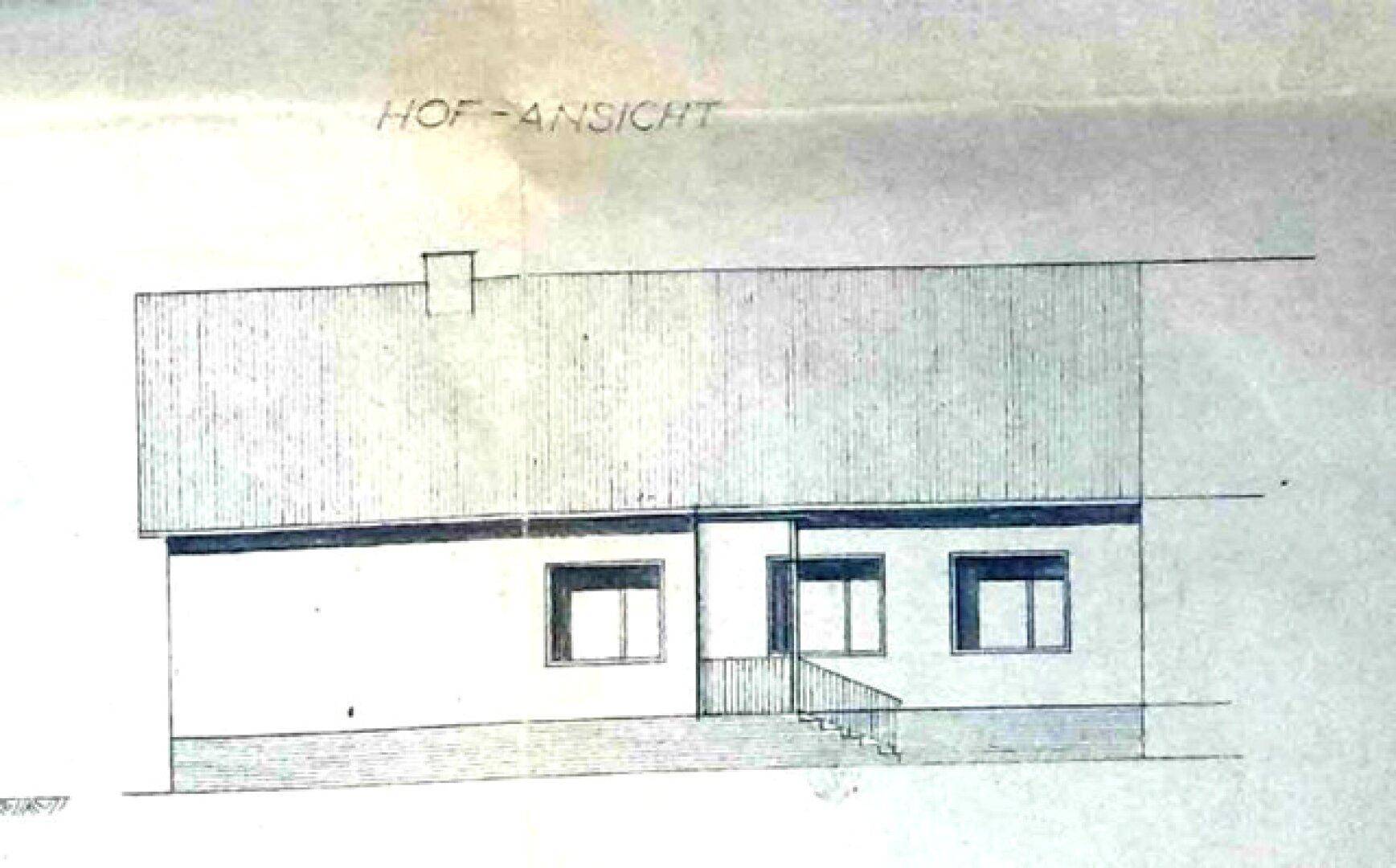 Hofansicht des Gebäudes mit einem Pultdach und einem Eingangsbereich mit Treppe.