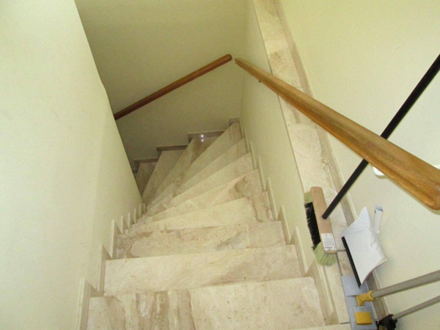 Elegante Treppe mit Marmorstufen und einem hölzernen Handlauf, der nach oben führt.
