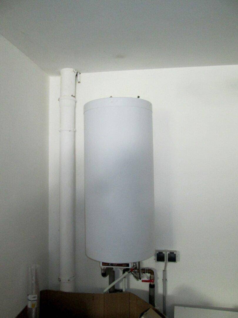 Ein Warmwasserspeicher oder Boiler in einem funktionalen Hauswirtschaftsraum.