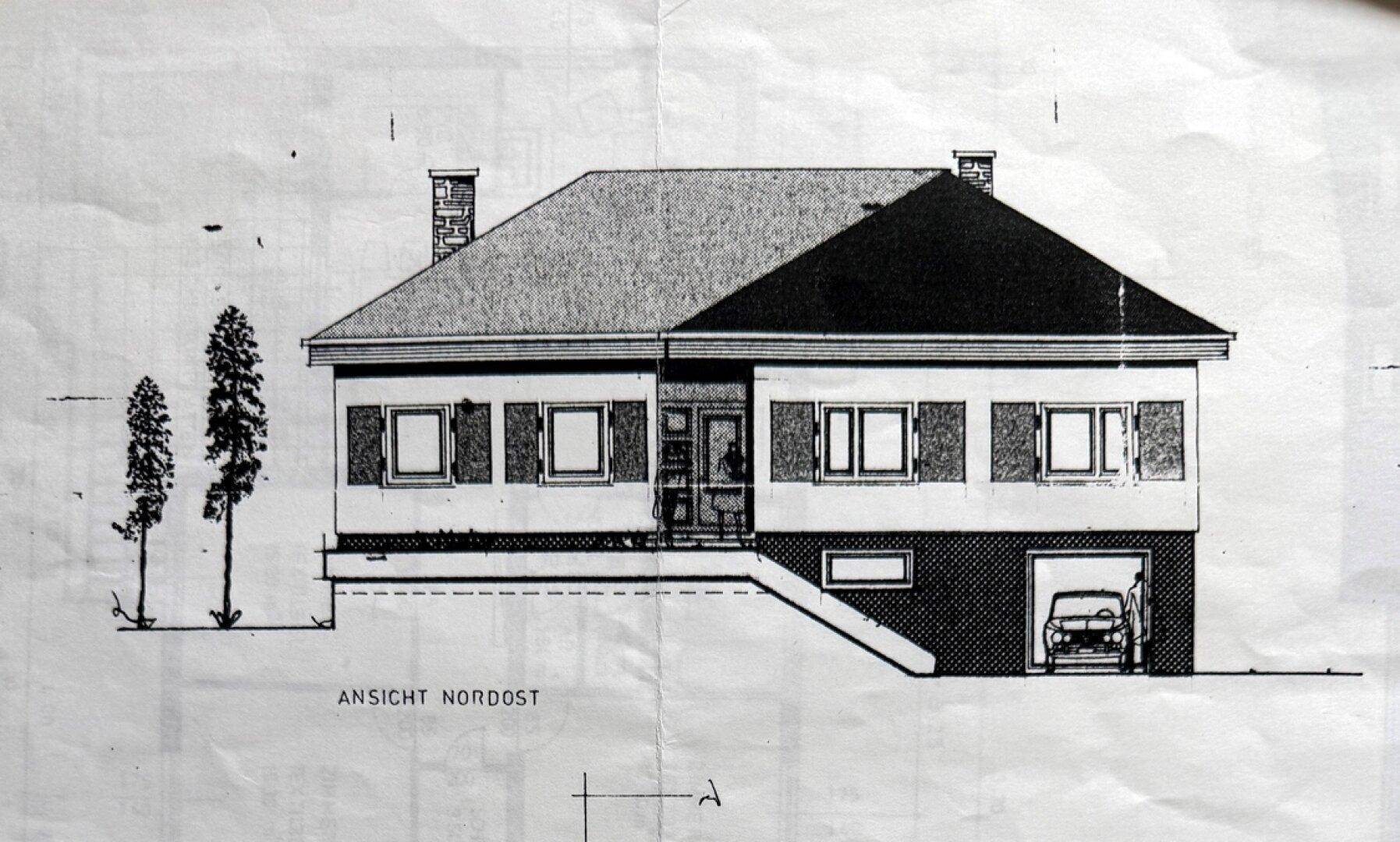 Architektonische Nordost-Ansicht des Hauses mit Fassadendetails und integrierter Garage.
