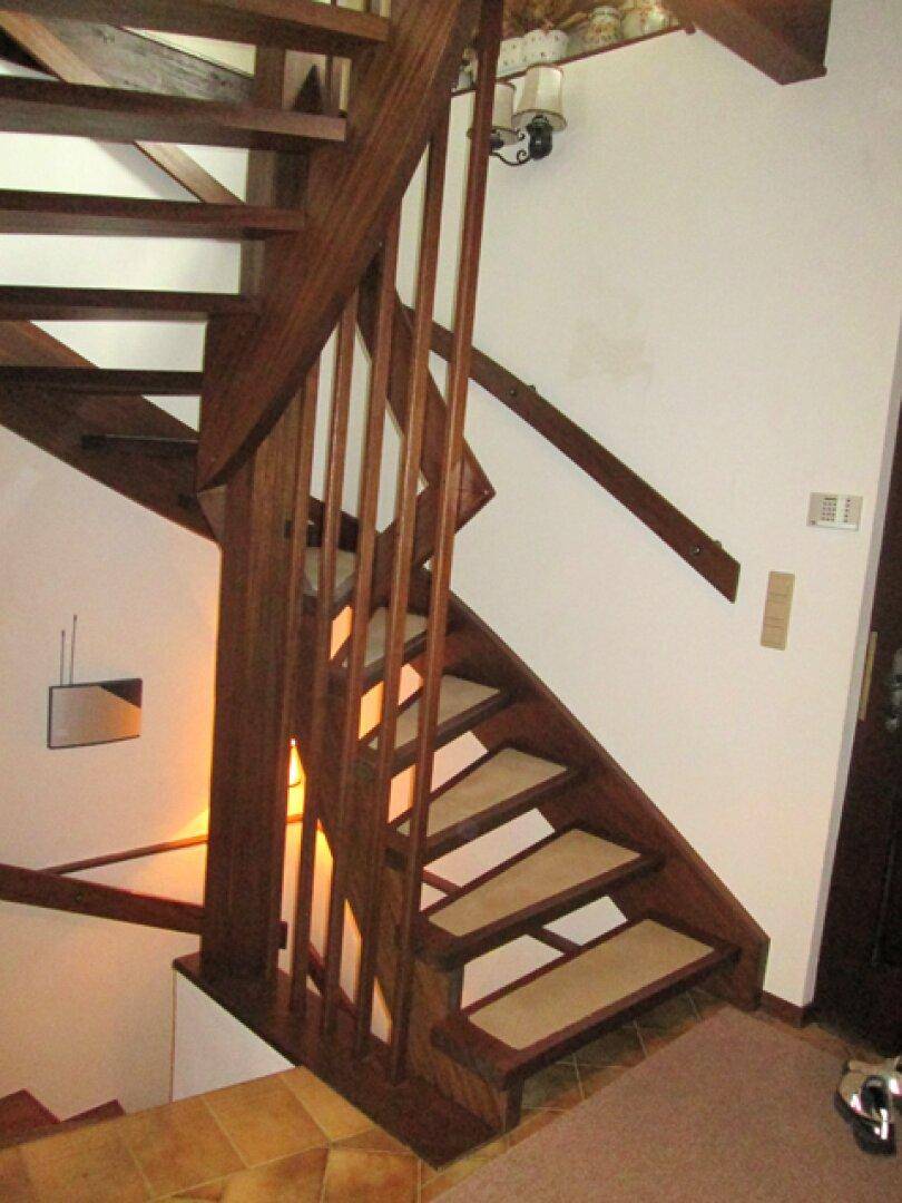 Holztreppe im Eingangsbereich, die die verschiedenen Etagen verbindet.