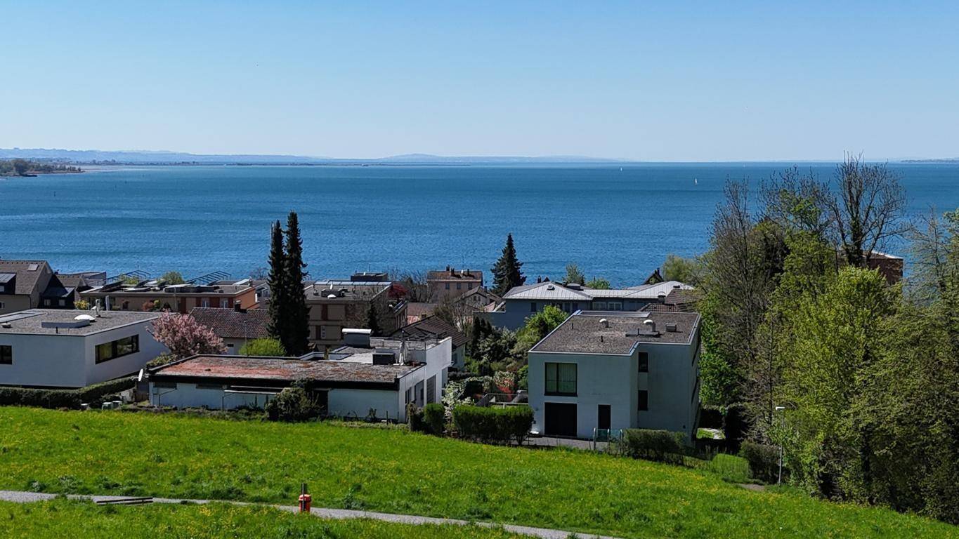 Weitläufiger Panoramablick auf den blauen See, umgeben von Häusern und einer malerischen Bergkulisse.