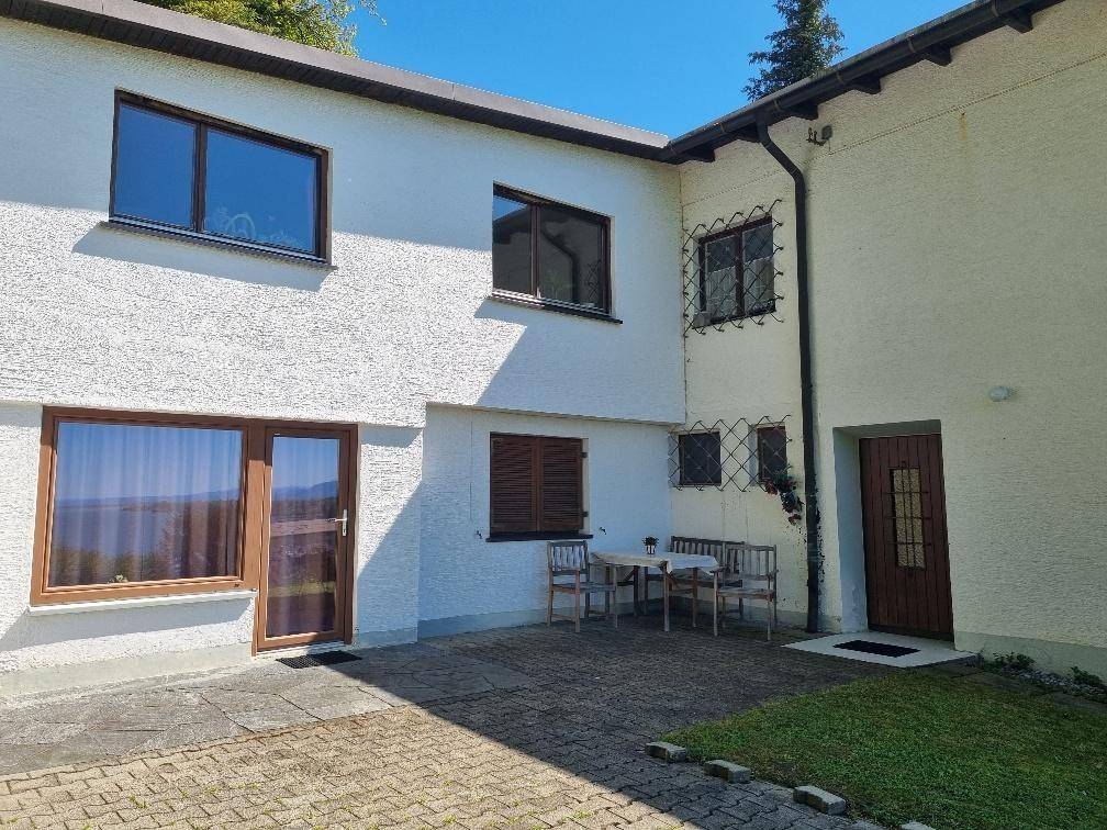 Gemütliche gepflasterte Terrasse mit Gartenmöbeln direkt am Haus, ideal für entspannte Stunden im Freien.