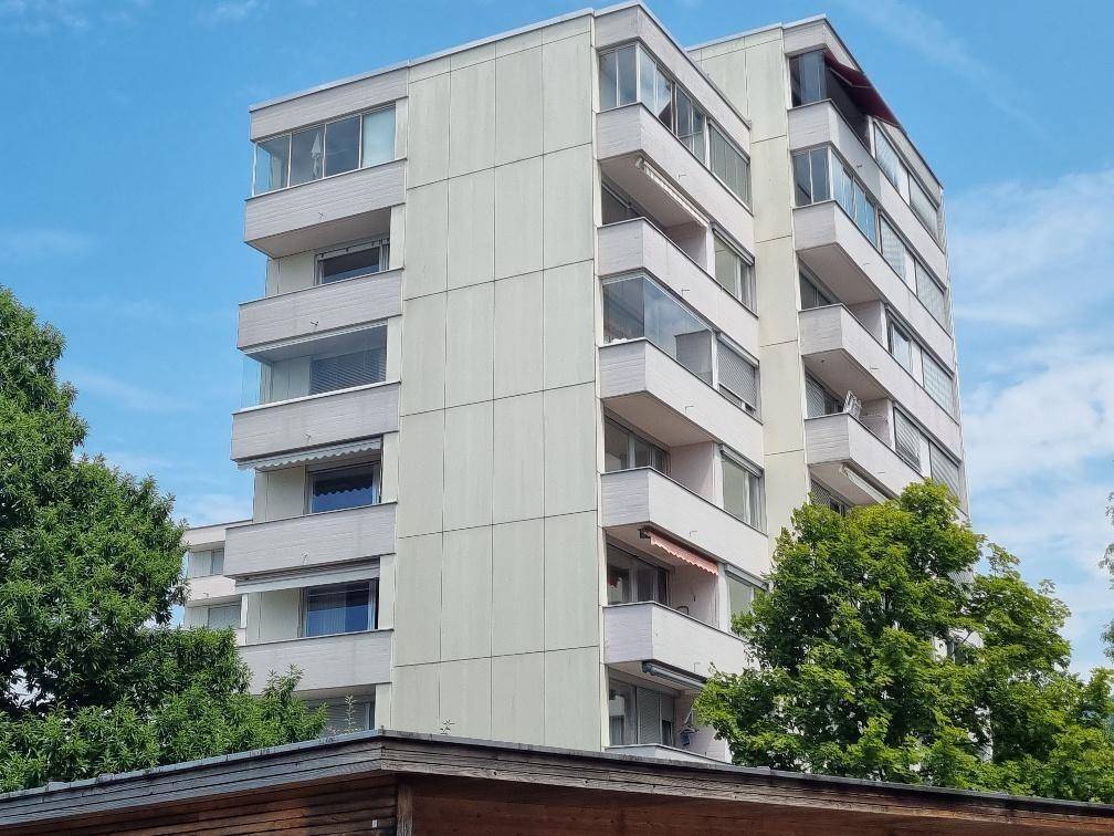 Mehrstöckiges Wohngebäude mit moderner Fassade und zahlreichen Balkonen.
