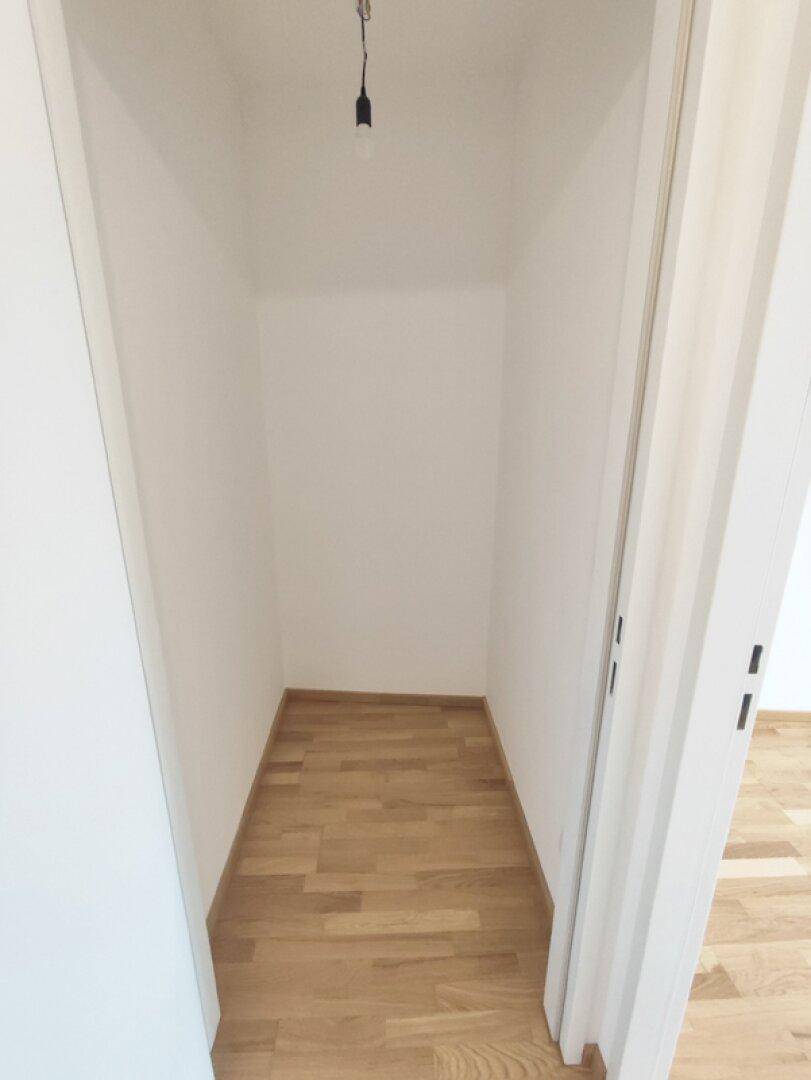 Kleiner, leerer Abstellraum mit hellem Parkettboden, ideal für zusätzlichen Stauraum.