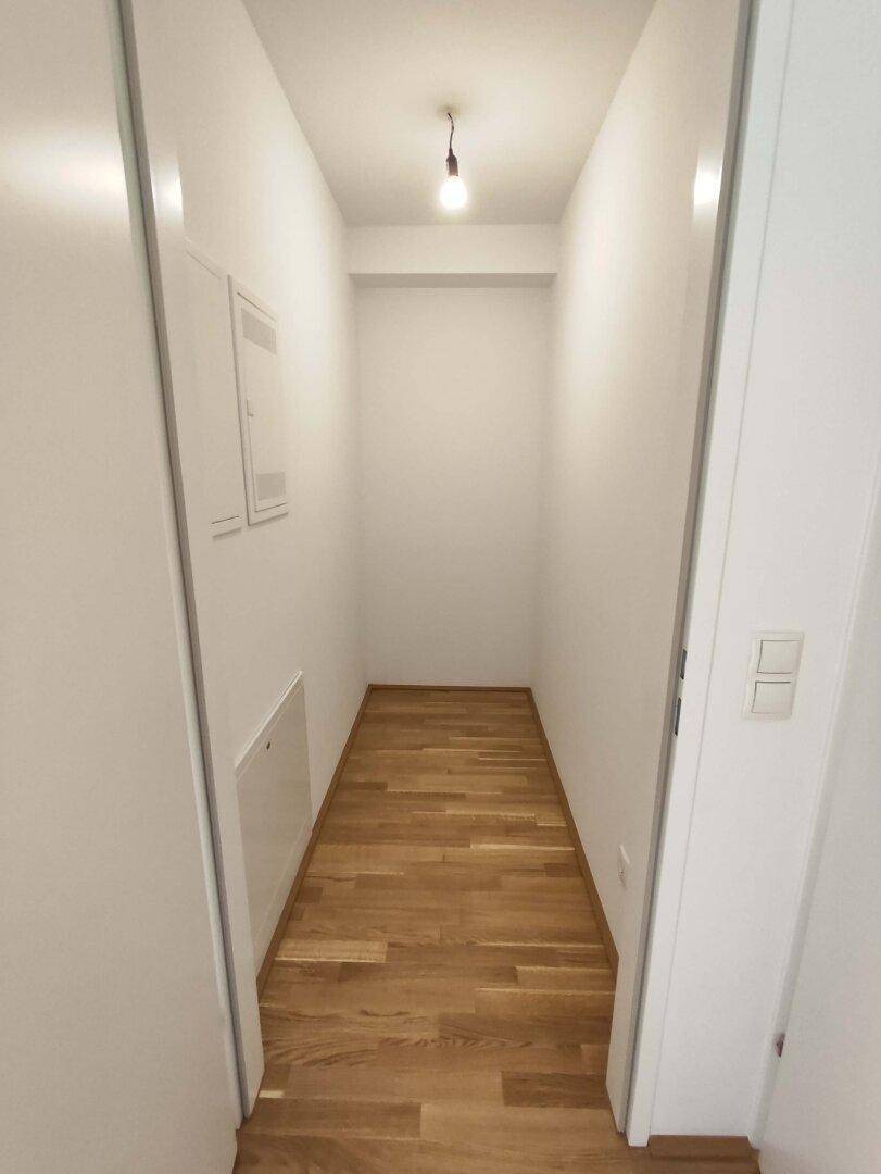 Schmaler Flur mit Parkettboden und Zugang zu weiteren Räumen.