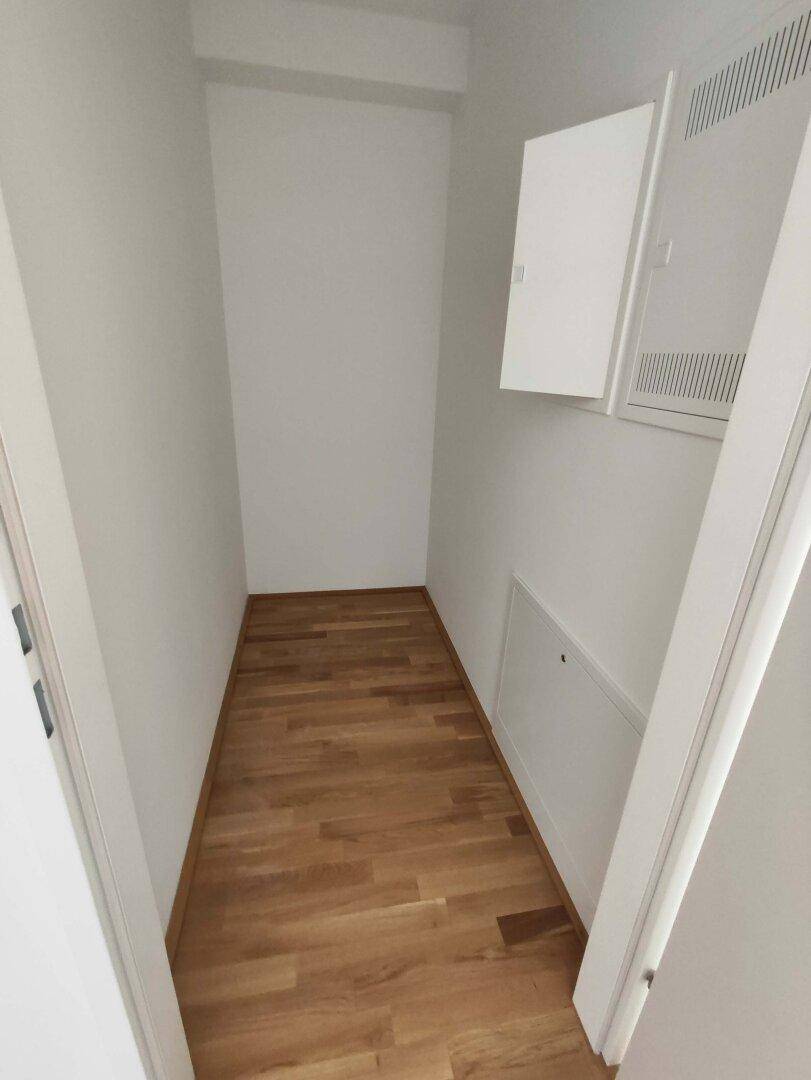 Praktischer Abstellraum mit Parkettboden und weißen Wänden, ideal für zusätzlichen Stauraum.