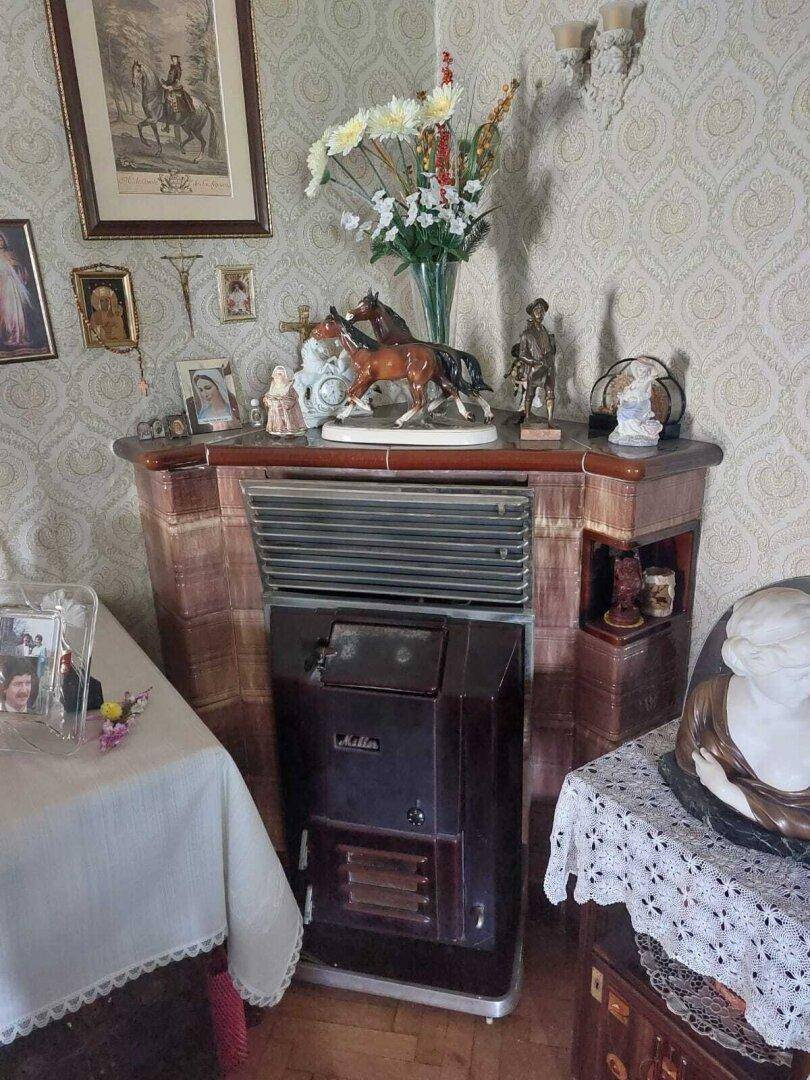 Gemütlicher Innenraum mit einem traditionellen Kachelofen und dekorativen Elementen.