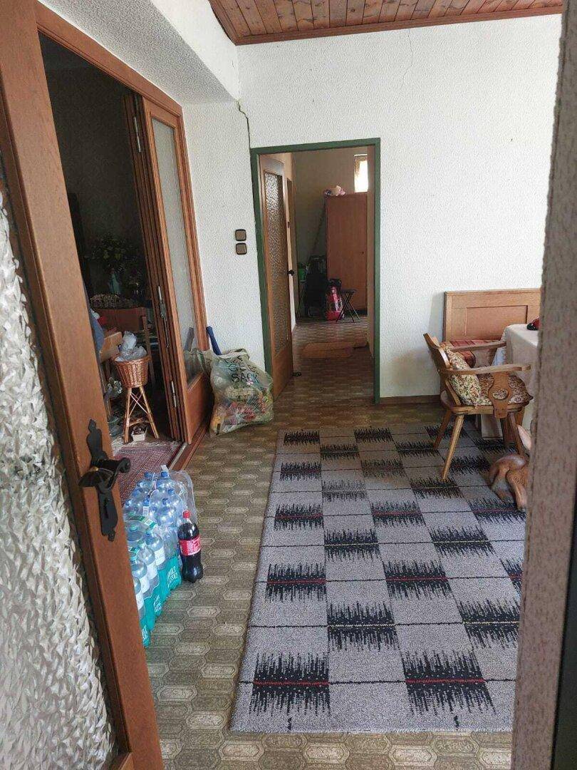 Eingangsbereich mit gemustertem Teppich, Holzdecke und Zugang zu weiteren Räumen.