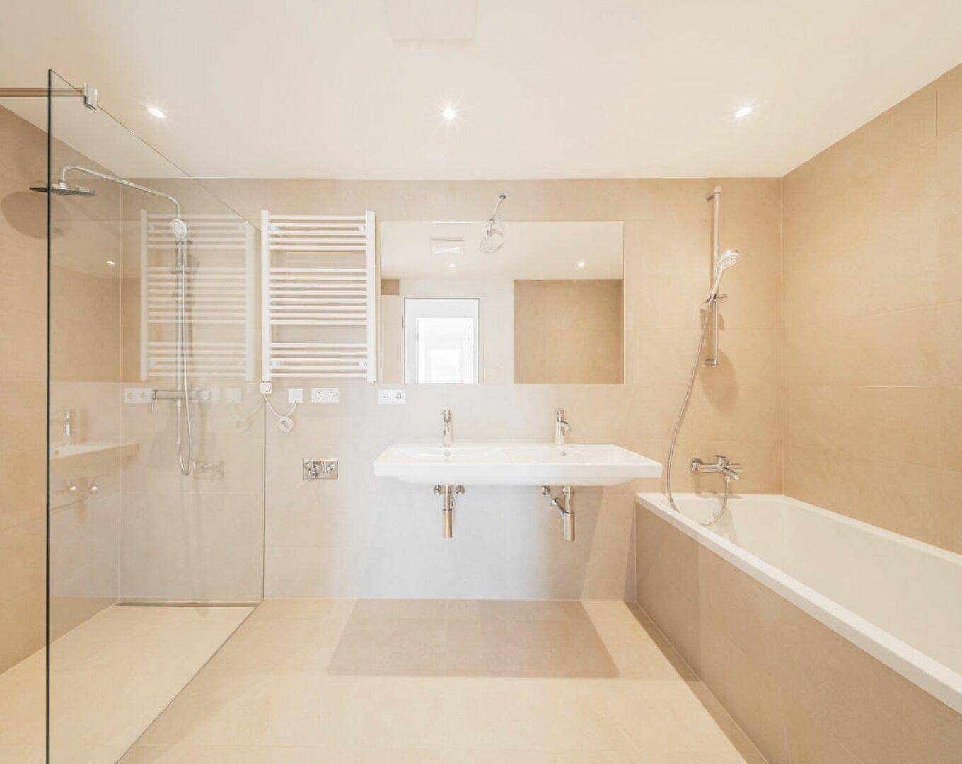 Modernes Badezimmer mit Badewanne, ebenerdiger Dusche und Doppelwaschbecken.