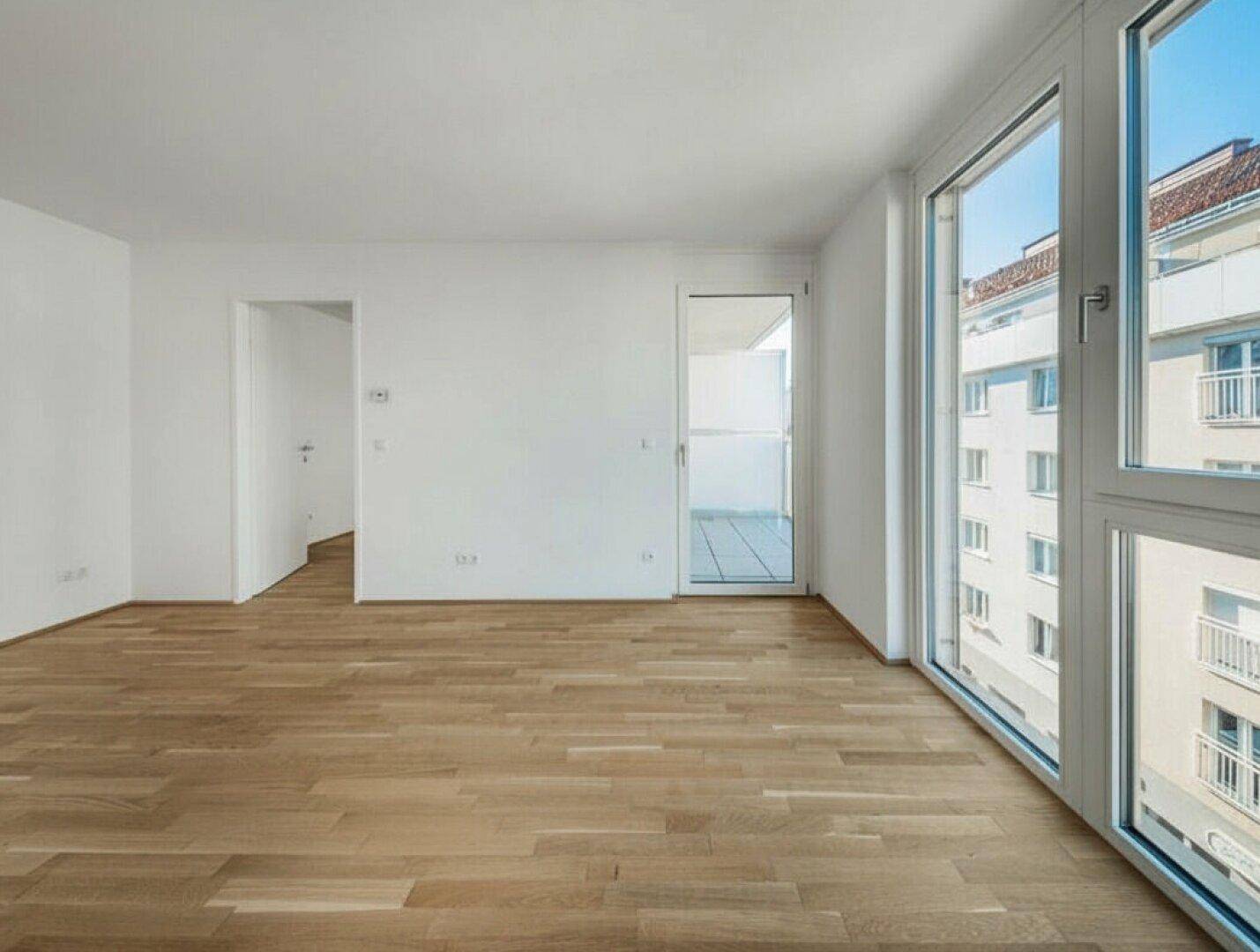 Helles, leeres Wohnzimmer mit Eichenparkettboden und großen Fenstern, die viel Tageslicht hereinlassen.