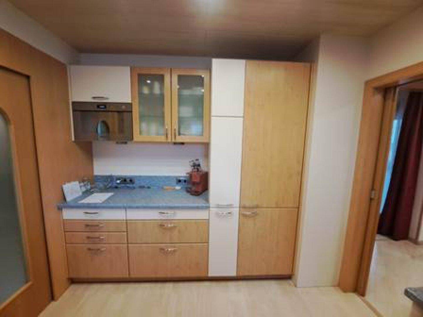 Helle Küche mit einer Kombination aus Holz- und weißen Schränken und Einbaugeräten.