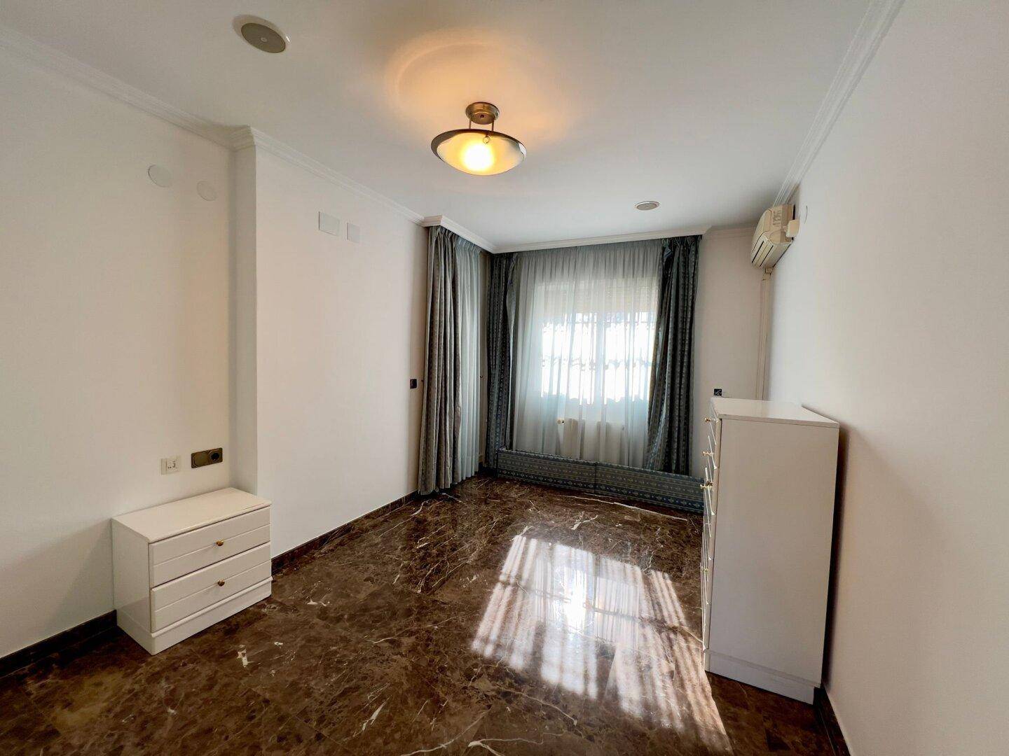 Schlafzimmer mit Fenster, das viel Tageslicht hereinlässt, und Klimaanlage für Komfort.