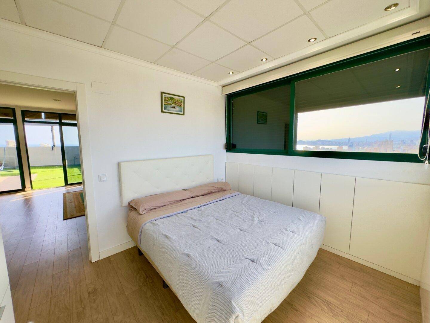 Helles Schlafzimmer mit Holzboden und weitem Blick auf die Umgebung.