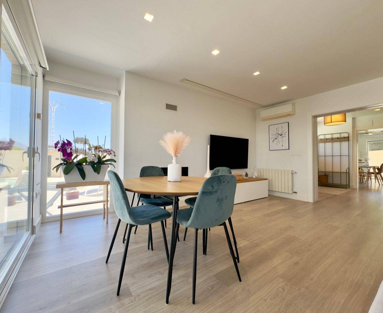 Heller Essbereich mit großen Schiebetüren, die Zugang zur Terrasse und viel Tageslicht bieten.