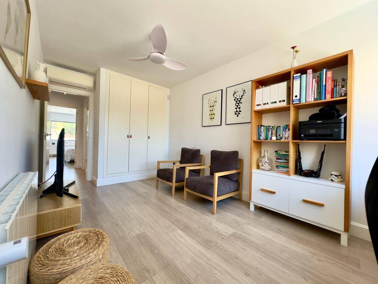 Arbeitszimmer mit integrierten Schränken, Bücherregal und Blick ins Grüne, bietet viel Stauraum.