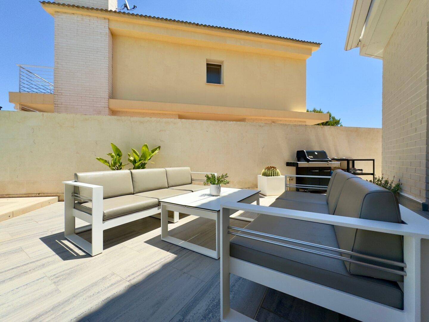 Gemütliche Außenterrasse mit Lounge-Möbeln und Grillbereich für gesellige Stunden.