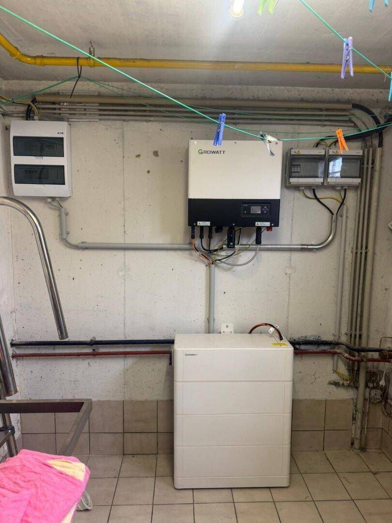 Technikraum im Keller mit Photovoltaik-Wechselrichter, Batteriespeicher und Wäscheleinen.