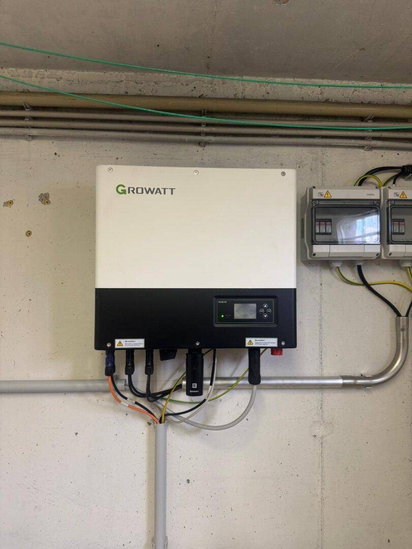 Nahaufnahme des Growatt Photovoltaik-Wechselrichters und der zugehörigen Elektroinstallationen.