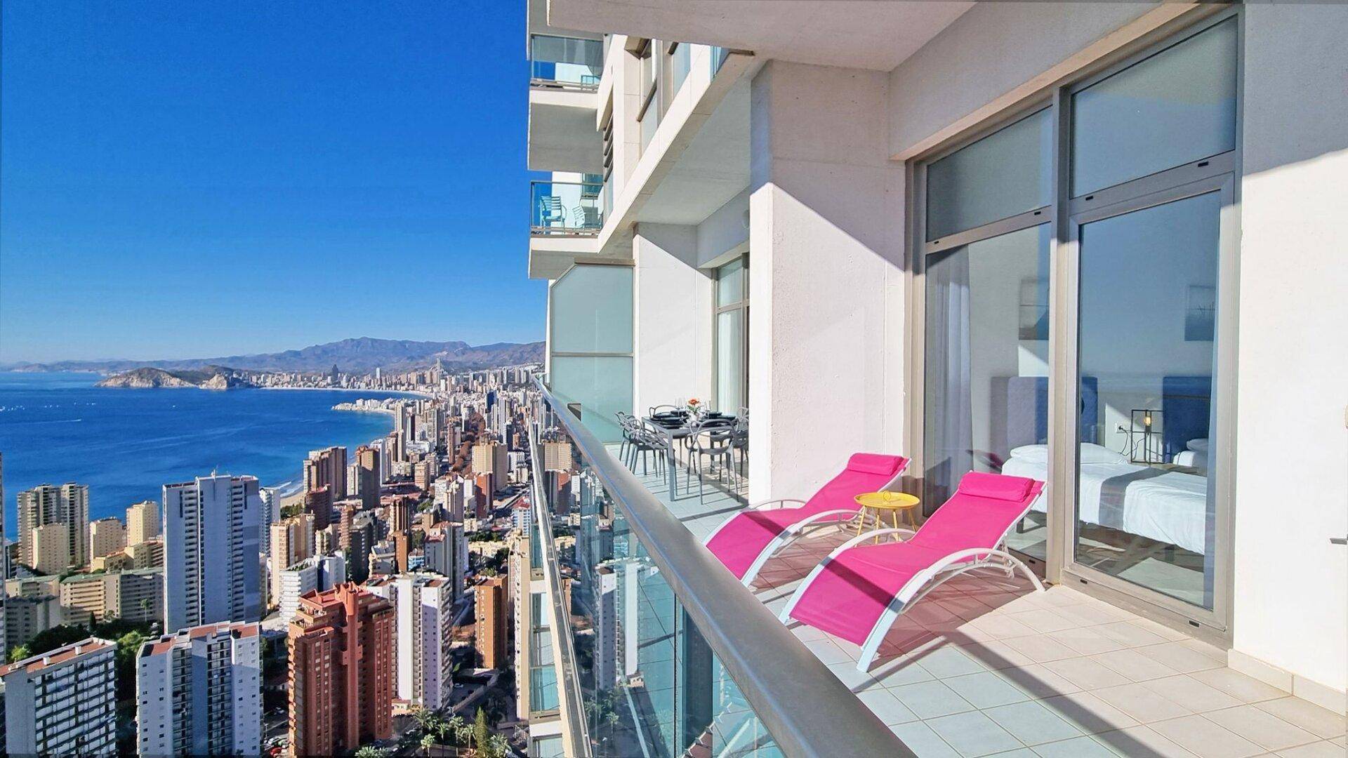 Geräumiger Balkon mit Liegestühlen, der einen atemberaubenden Blick auf die Stadt und das Meer bietet.