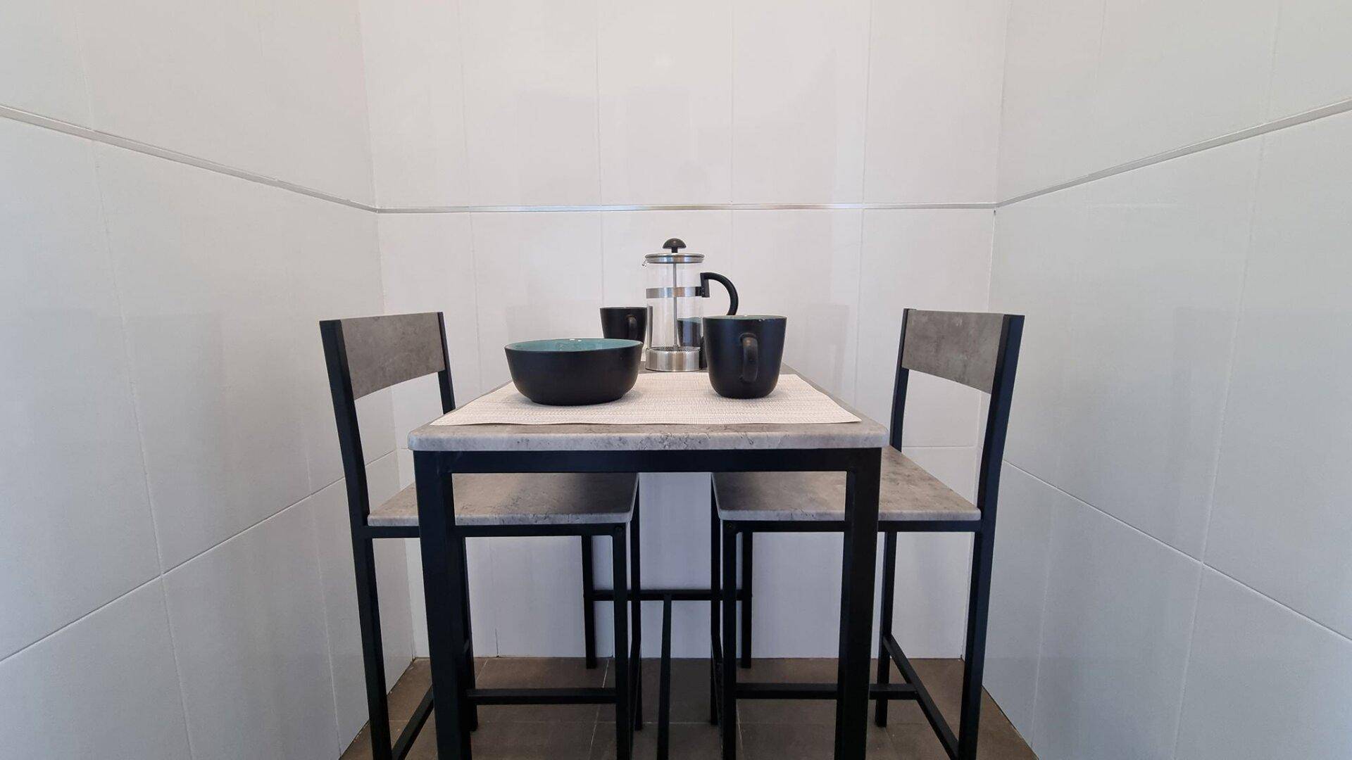 Kleiner, gemütlicher Essbereich mit modernem Tisch und Stühlen, ideal für ein Frühstück.