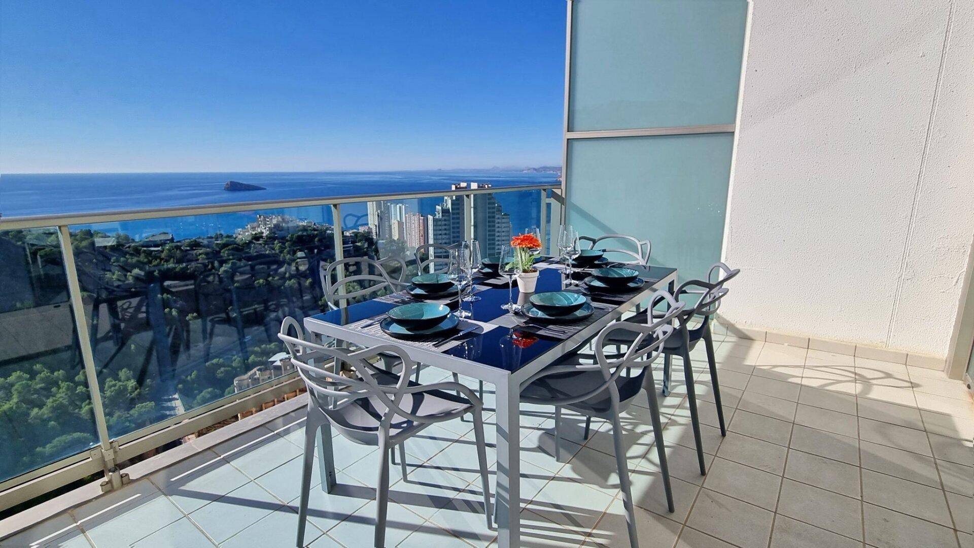 Einladender Balkon mit Esstisch und Stühlen, perfekt für Mahlzeiten im Freien mit Meerblick.