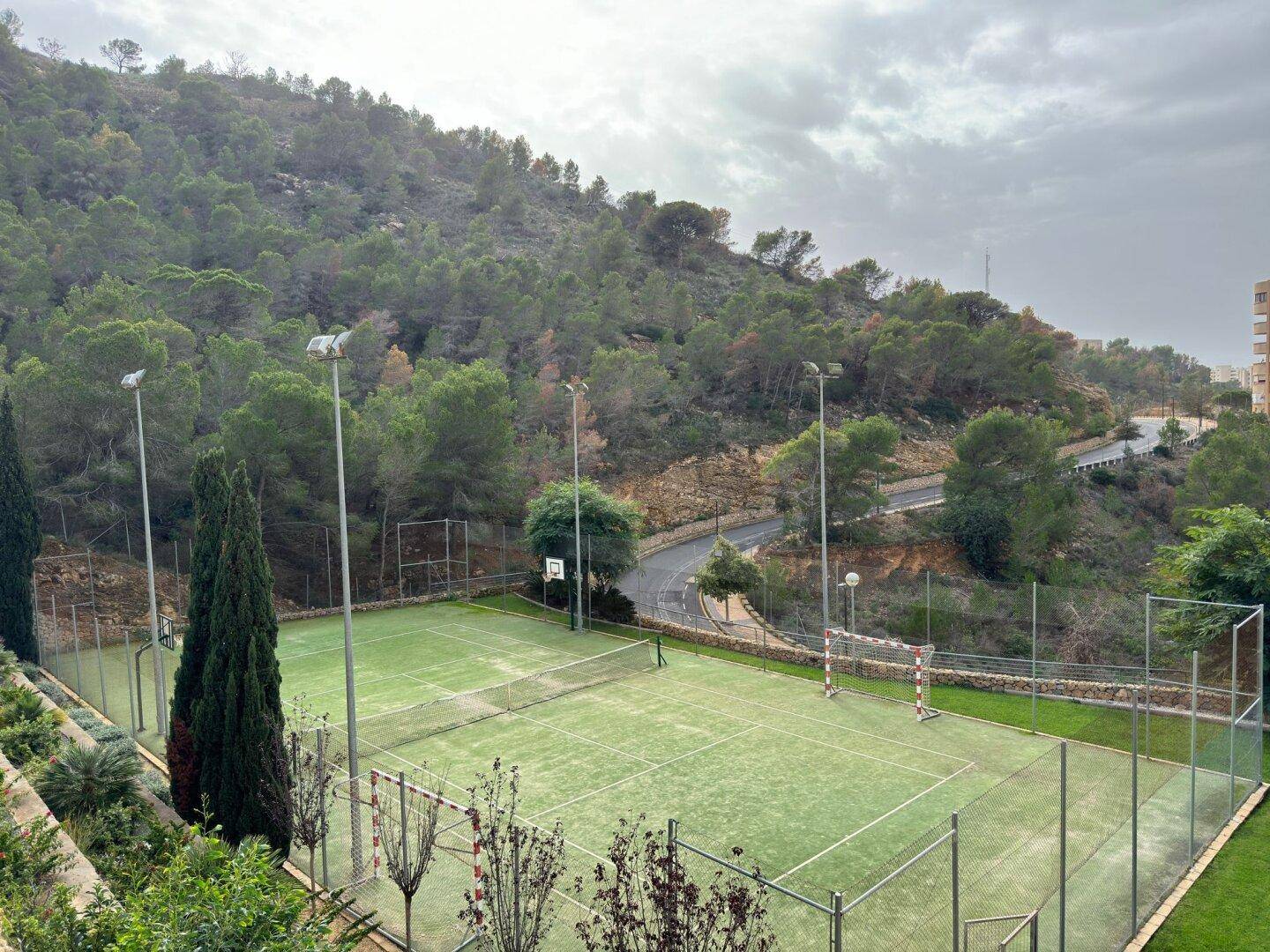 Vielseitige Sportplätze für Tennis und Basketball, eingebettet in eine grüne Hügellandschaft.