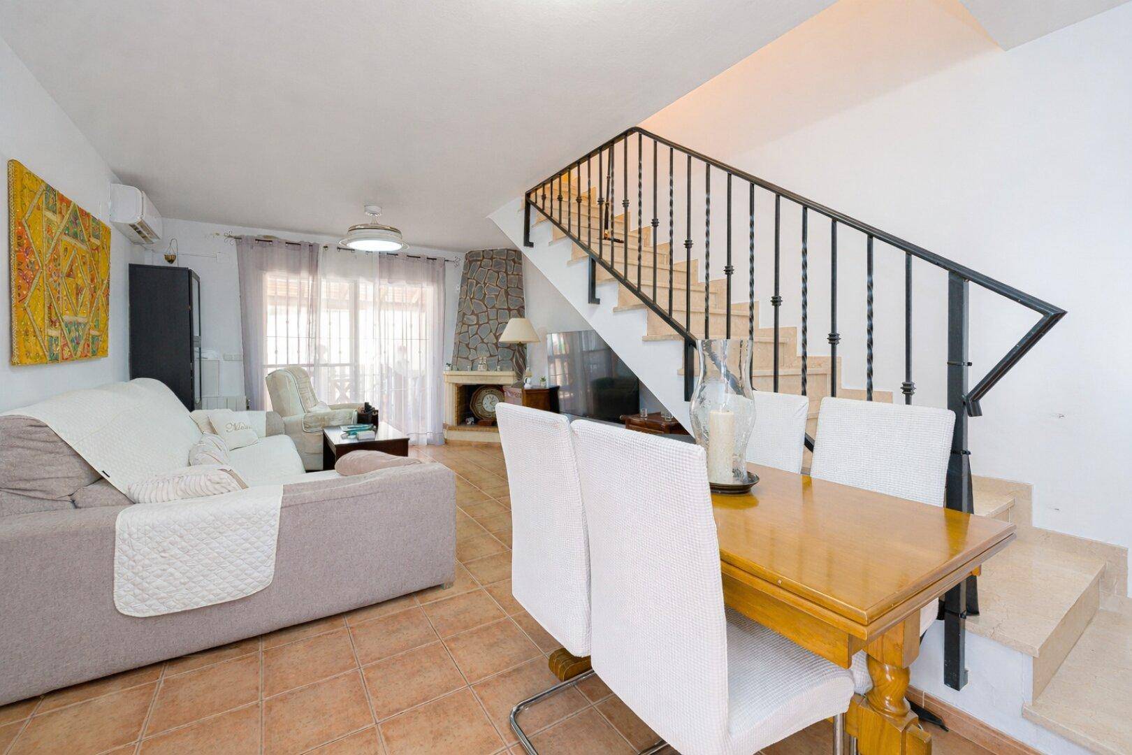 Offener Wohn- und Essbereich mit Terrakottafliesen und Treppe, ideal für geselliges Beisammensein.