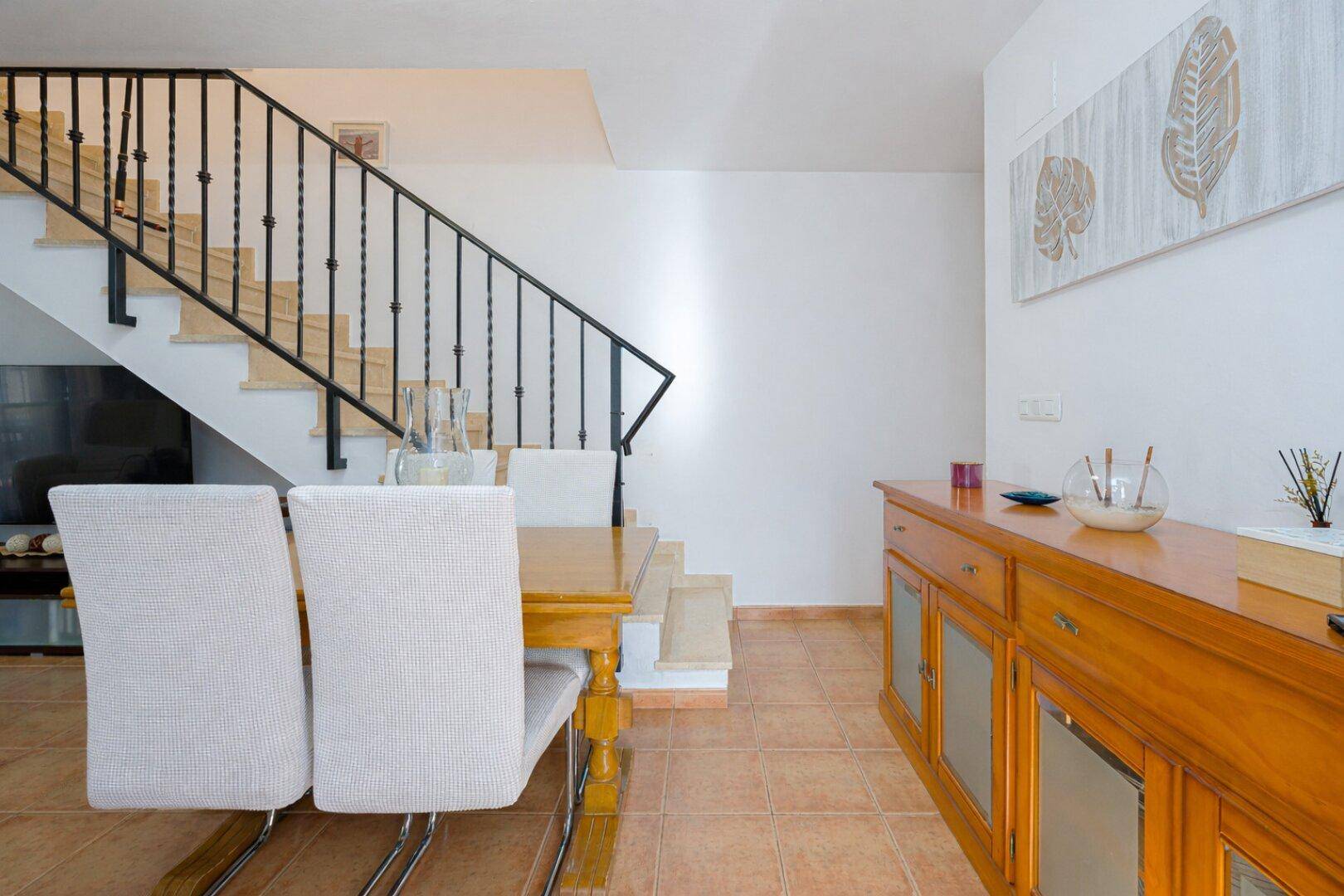 Essbereich mit Holztisch, Sideboard und Treppe zum Obergeschoss, hell und geräumig.